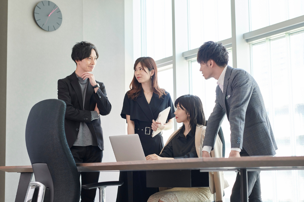 オフィスで打ち合わせをする30代前後の社員たち